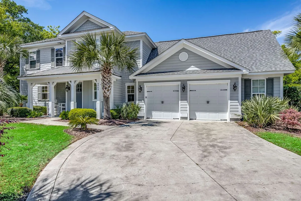 The image showcases the welcoming exterior of a spacious single-family house, framed by swaying palm trees, with a charming front porch perfect for relaxing. The scene conveys a sense of warmth and hospitality, highlighting ample space for family gatherings or relaxing moments outdoors.